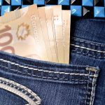 A close up image of Canadian $100 bills in the pocket of a young girls jeans.